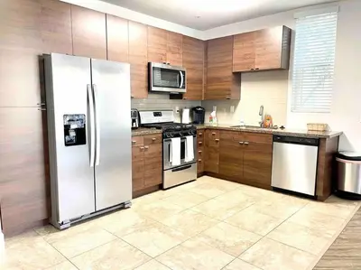 a kitchen with stainless steel appliances and wooden cabinets at Spacious 2 Bedroom Venice Beach Villa in Los Angeles