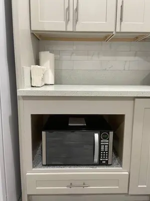 a microwave in a cabinet in a kitchen at New! Modern Gated Summer Getaway Home in Rosemead