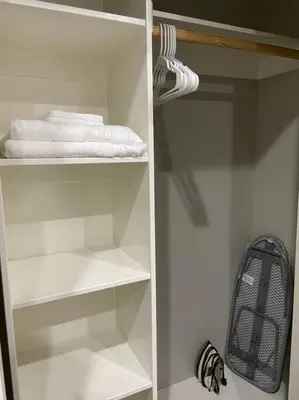 a white closet with white towels and a backpack at New! Modern Gated Summer Getaway Home in Rosemead