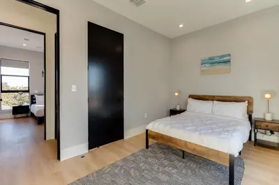a bedroom with a bed and a large window at Brand New Modern 9 Bedroom Compound in Pickfair Village in Los Angeles