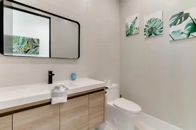 a bathroom with a sink and a mirror at Brand New Modern 9 Bedroom Compound in Pickfair Village in Los Angeles