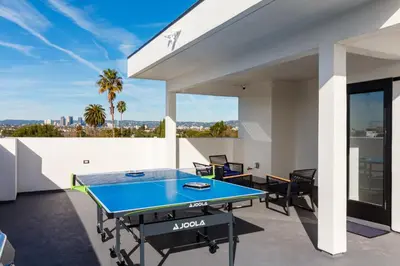 a ping pong table on the balcony of a house at Brand New Modern 9 Bedroom Compound in Pickfair Village in Los Angeles