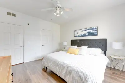 a white bedroom with a bed and a ceiling fan at Spacious, Comfortable, and Central Condo in Los Angeles