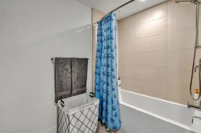 a bathroom with a blue shower curtain and a tub at 13 Luxury apartment in Los Angeles