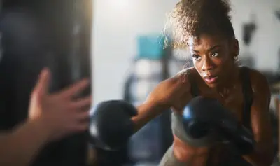 a woman with boxing gloves in front of a mirror at Luxe MDR apartment,Parking, Gym, Pool, jacuzzi,BBQ in Los Angeles