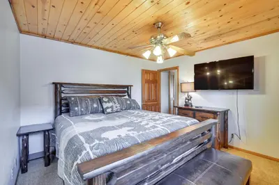 a bedroom with a bed and a flat screen tv at Big Bear Lake Cabin with Hot Tub and Gas Fire Pit! in Big Bear Lake