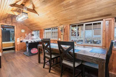 a dining room with a table and chairs and a stove at Warbler's Roost - Perfect vintage cabin in the woods in Big Bear Lake