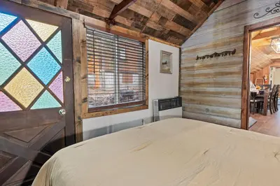 a bedroom with a bed and a window at Warbler's Roost - Perfect vintage cabin in the woods in Big Bear Lake