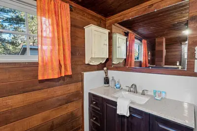 a bathroom with a sink and a mirror at Warbler's Roost - Perfect vintage cabin in the woods in Big Bear Lake