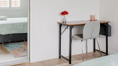 a desk with a chair next to a bed at Private Pool Retreat Near Disney Game Room & Firepit in Fullerton