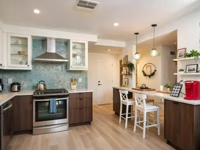 a kitchen with wooden cabinets and an island with bar stools at Private Pool Retreat Near Disney Game Room & Firepit in Fullerton