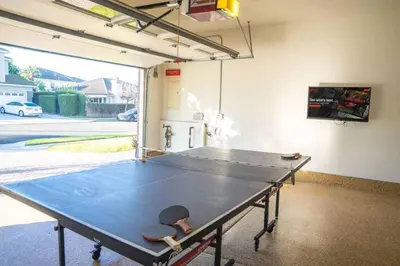 a ping pong table in a garage with a ping pong ball at Spacious Disney Retreat with Pool Table Fire Pit in Placentia