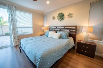 a bedroom with a bed with blue sheets and a window at Spacious Disney Retreat with Pool Table Fire Pit in Placentia
