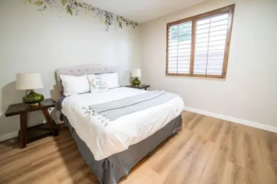 a white bedroom with a bed and a window at Spacious Disney Retreat with Pool Table Fire Pit in Placentia