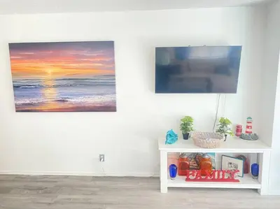 a white table in a room with a painting on the wall at Sea View, Boards, Bikes, W/d in Oxnard