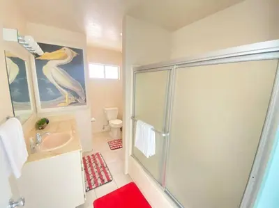 a bathroom with a penguin painting on the wall and a shower at Sea View, Boards, Bikes, W/d in Oxnard