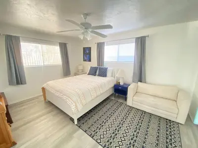 a bedroom with a bed and a chair and a ceiling fan at Sea View, Boards, Bikes, W/d in Oxnard