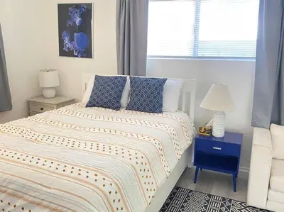 a bedroom with a bed with blue pillows and a window at Sea View, Boards, Bikes, W/d in Oxnard