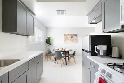 a kitchen with white counters and a table with chairs at 5 Mins to DT Alhambra - Homey 2BR Apt 4A in Alhambra