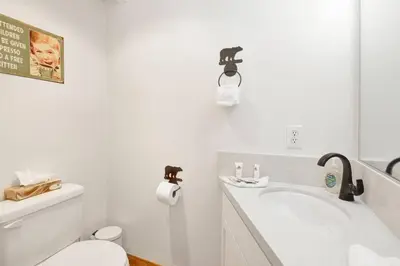 a white bathroom with a toilet and a sink at Chairlift Lodge Bg Bear~ Walk to Lift Condo~ in Big Bear Lake