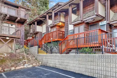 an apartment building with orange balconies and a parking lot at Chairlift Lodge Bg Bear~ Walk to Lift Condo~ in Big Bear Lake