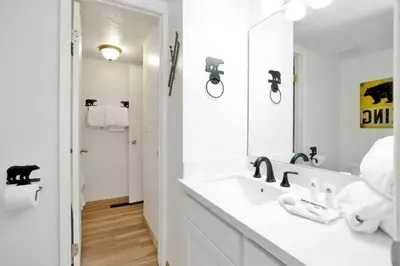 a white bathroom with a sink and a mirror at Chairlift Lodge Bg Bear~ Walk to Lift Condo~ in Big Bear Lake