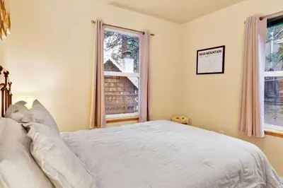 a bedroom with a white bed and two windows at Mount Berkley Big Bear~ Walk to Village~ Games~ in Big Bear Lake