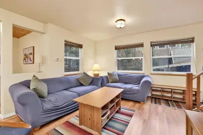 a living room with a blue couch and a table at Mount Berkley Big Bear~ Walk to Village~ Games~ in Big Bear Lake