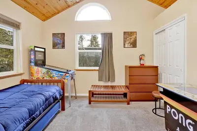 a bedroom with a bed and a dresser and a window at Mount Berkley Big Bear~ Walk to Village~ Games~ in Big Bear Lake