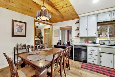 a kitchen and dining room with a wooden table and chairs at Timber Pines Chalet~ Hot Tub~ Walk to Lake/Marina~ in Big Bear Lake