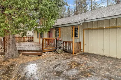 a house with a garage and a tree at Timber Pines Chalet~ Hot Tub~ Walk to Lake/Marina~ in Big Bear Lake