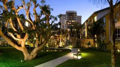 a park with a tree and a bench next to a building at Marina Life: Smell the Sea, Feel the Breeze in Los Angeles