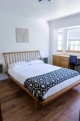a bedroom with a bed and a desk and a window at Apres-Ski Chalet Mt High Wrightwood Ski Resort in Wrightwood
