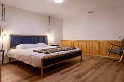a bedroom with a large bed and a chair at Apres-Ski Chalet Mt High Wrightwood Ski Resort in Wrightwood