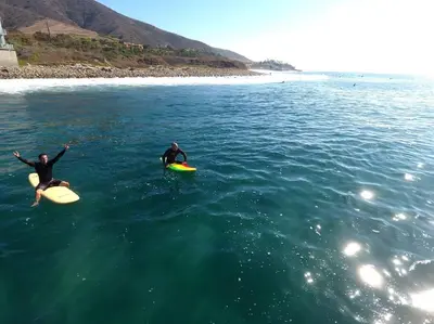 two people riding on surfboards in the water at Malibu Best Kept Secret in Malibu
