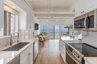 a kitchen with white cabinets and a view of the ocean at Malibu Best Kept Secret in Malibu