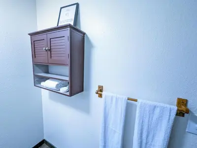 a bathroom with a towel rack with a cabinet and towels at Fox n Bear Cottages Big Bear in Big Bear Lake