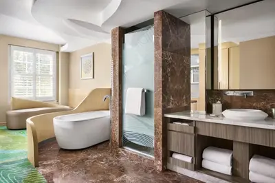 a bathroom with a tub and a sink and a mirror at Pasadena Hotel & Pool in Pasadena