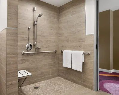 a bathroom with a shower stall with towels at Pasadena Hotel & Pool in Pasadena