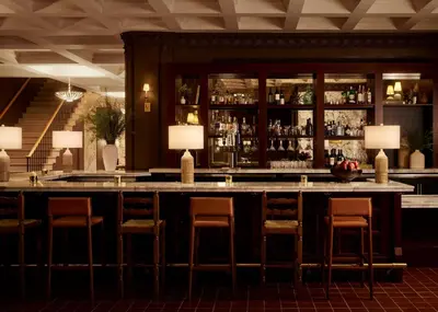 a bar with chairs and a counter in a room at Pasadena Hotel & Pool in Pasadena