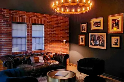 a living room with leather furniture and a brick wall at The Chateau in Lake Arrowhead