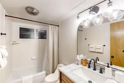 a bathroom with a sink and a toilet and a mirror at Pinecrest Paradise in Crestline