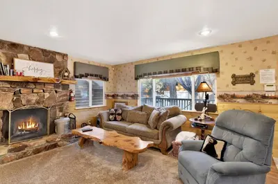 a living room with a couch and a fireplace at Big Bear Happy Place~ Hot Tub~ Games~ Walk to Village~ in Big Bear Lake