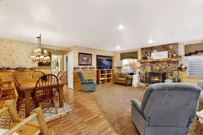a living room with a table and a fireplace at Big Bear Happy Place~ Hot Tub~ Games~ Walk to Village~ in Big Bear Lake