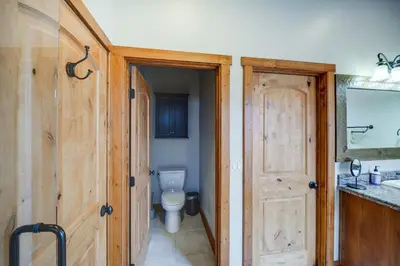 a bathroom with a toilet and a sink and a door at Pine Mountain Club Cabin with Private Deck and Views! in Pine Mountain Club