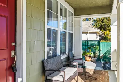 a porch with two chairs and a red door at Olivia Oasis in Oxnard