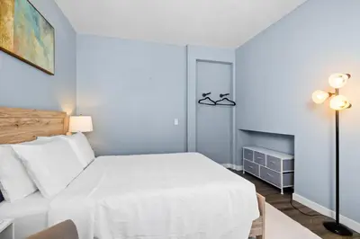 a bedroom with a white bed and a lamp at Olivia Oasis in Oxnard