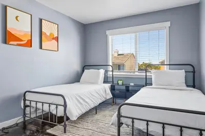 two beds in a room with a window at Olivia Oasis in Oxnard