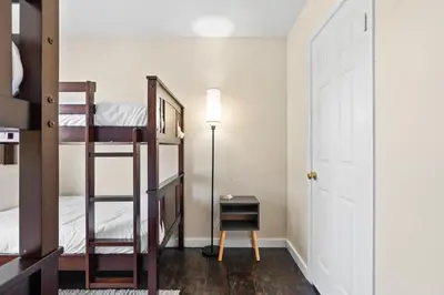 a bedroom with bunk beds and a desk and a lamp at Olivia Oasis in Oxnard
