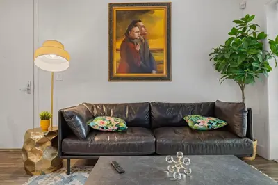 a leather couch in a living room with a painting on the wall at 11 Best Walk location of SM in Los Angeles